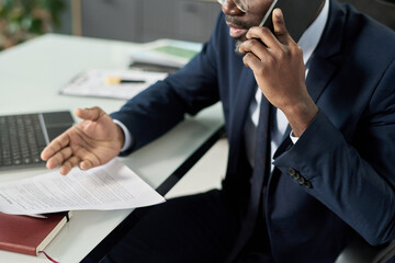 Poster - Businessman sitting at table in office and discussing contract on the phone with customer
