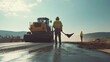 © Mcgui - Asphalt worker paving a new road section with industrial machinery. Featuring teamwork and endurance