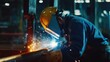 © keshia - A construction worker welding pipes together in a factory. Featuring expertise and precision