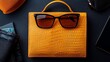 © SatoruArt - A yellow handbag is paired with sunglasses, set against a dark background and other accessories