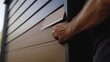 © Soulc - Construction worker installing siding on the exterior of a house. Featuring skill and craftsmanship