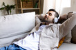 © Daniel - Relaxed man listening to music with headphones lying on the couch. Male relaxing on the sofa.