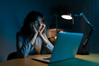 © Daniel - Tired woman working late at night using laptop at home office.