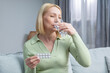 © zinkevych - Blonde woman in her 50s taking hormone replacement pills