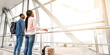 © Prostock-studio - Air Travel. Black Millennial Couple Standing Together Near Window In Airport, Looking At Flying Plane, Happy African American Man And Woman With Luggage Waiting For Flight Boarding, Low Angle View
