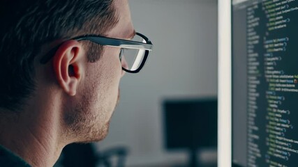 Aufkleber - Close up profile view of a focused software developer wearing glasses, examining lines of code displayed on a computer monitor in a dark office environment