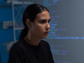 young hispanic female software developer working on computer for coding software program in office. 