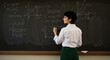 © Noordeen - teacher in front of blackboard, female teacher in classroom, Blackboard with math and science by writing on the blackboard