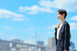 © Peak River - 青空をバックに立つビジネスウーマン