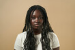 © Retamosa - Young black woman posing with long braided hair on beige background