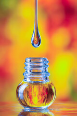 Poster - Close up of amber dropper bottle dripping essential oil into diffuser with warm ambient light