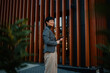 © Zamrznuti tonovi - Businesswoman holding tablet and smiling outside modern office building
