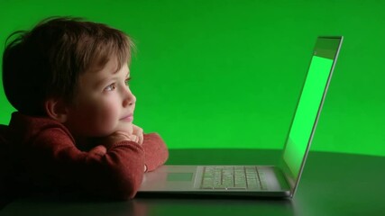 Poster - Young Boy Fixated on Laptop With Green Backdrop Generative AI