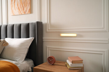 Aufkleber - Glowing modern LED lamp on white wall in near bed indoors