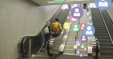 Poster - Image of social media icons floating over happy caucasian couple holding hands on escalators