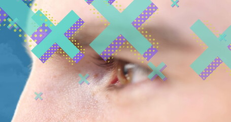 Poster - Image of cross icons over eye of caucasian man on blue background