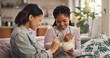 © peopleimages.com - Bonding, ice cream and woman friends on sofa in living room of home together for reunion or visit. Conversation, relax and sharing with happy people in apartment for gossip, relationship or social