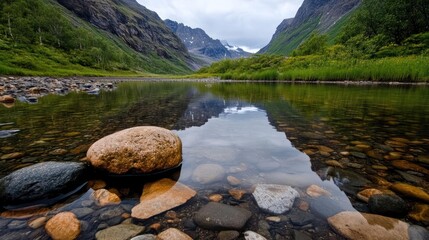 Poster - Captivating landscape featuring a serene river with clear water reflecting the majestic snow-capped mountains and lush green valley, showcasing the untouched beauty of nature