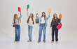 © master1305 - Four students standing in confident poses, raising books and backpacks in air with cheerful expressions, celebrating end of study session. Concept of education, students, joy, motivation.