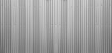 Silver tin iron corrugated wall with horizontal stripes from a metal profile of a metal sheet. Texture, background. grey wall fence texture for backdrop galvanized gray facade.