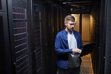 Poster - IT professional working in a server room managing hardware and software with focused expression. Surrounded by server racks filled with equipment, creating tech-focused environment