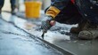 © LorelEino - Laborer sealing joints on a concrete foundation at a construction site. Featuring detail and quality control