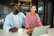 © NDABCREATIVITY - Man and woman working remotely using laptop. Male female freelancers working together. Digital nomad