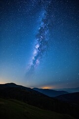 Wall Mural - milky rising over the mountains and a grassy hill