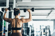 © 2B - Woman lifting weights in a gym while focusing on strength training and fitness during afternoon workout