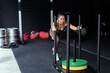 © 2B - Fitness enthusiast pushes sled while training at a gym
