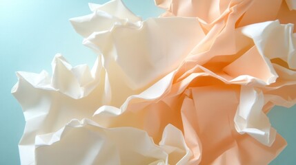 Leinwandbilder - Close-up shot of crumpled ivory and light orange fabric on a teal surface. The soft lighting accentuates the texture and folds of the fabric, creating an abstract and elegant composition