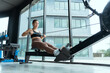 © 2B - Rowing workout session in a modern gym with large windows showcasing natural light