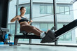 © 2B - Rowing workout session in a modern gym with large windows showcasing natural light