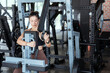 © 2B - Fitness enthusiast performs strength training at a well-equipped gym during daytime