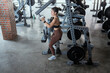 © 2B - Fitness enthusiast performs strength training at a well-equipped gym during daytime