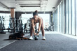 © 2B - Woman exercises with kettlebell in modern gym while dog relaxes nearby