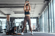 © 2B - Woman exercises with weights in gym while dog relaxes nearby during morning workout session