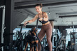 © 2B - Woman exercises with dog using battle ropes in a modern gym environment during daytime