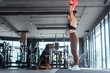 © 2B - Woman exercises with a weighted ball while a dog watches in a modern gym setting during a daytime workout