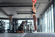 © 2B - Woman exercises with a weighted ball while a dog watches in a modern gym setting during a daytime workout