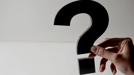 Aufkleber - Woman hand holds a big black question mark on a white background, representing frequently asked questions, uncertainty, and decision making