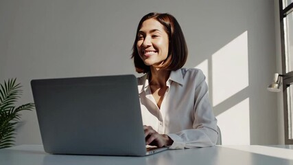 Aufkleber - Businesswoman sits at a white table, using her laptop and showcasing a range of emotions from focused concentration to a bright, cheerful smile, suggesting a positive and productive work session