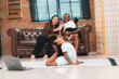 © chokniti - Heartwarming family moment as an African American father and daughter share playful time together on the couch, surrounded by love, laughter, and the warmth of home, while mom gently looks on with joy