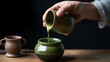 © Sumonrat - Close-up of hands pouring matcha into a ceramic container