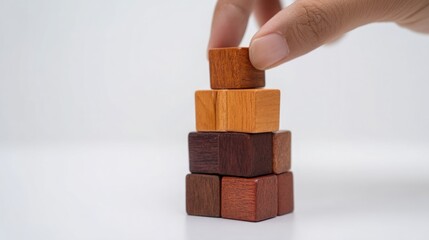 Poster - Person placing a wooden block on top of a stack to illustrate incremental growth and development in progress