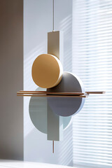 Poster - minimalist hanging sculpture with geometric shapes in soft pastel tones and golden rods, casting sha