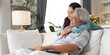 © winnievinzence - Asian senior woman embracing husband on couch afther finish working with laptop. Family love and support concept. Couple spending time together at home