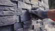 © MutshI - Mason installing stone veneer on exterior wall. Featuring stone veneer installation