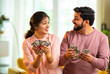 © StockImageFactory - Happy Indian couple holding and showing rupee notes, symbolizing unexpected financial success