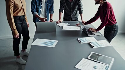 Aufkleber - Business team collaborating on a project, analyzing data on laptops and printed documents, engaging in discussion and strategic planning around a table in a modern office environment